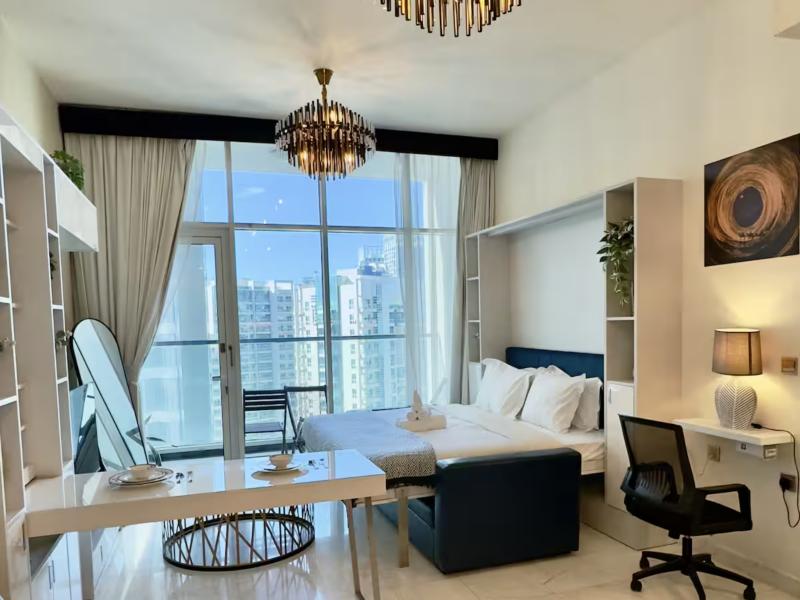 Studio with bed, dining table and full-height windows