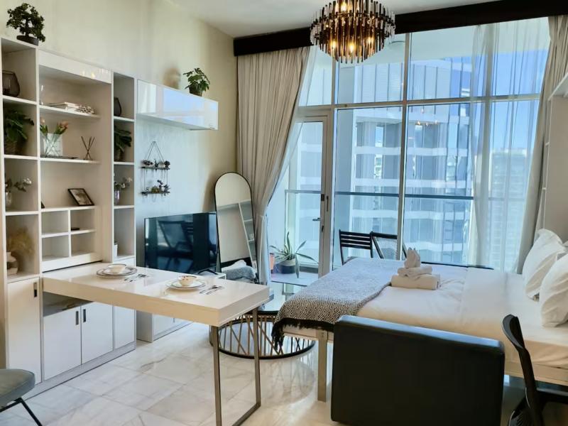 Bright studio with shelving, TV and bed by the window